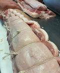 Raw porchetta, rolled and tied by hand